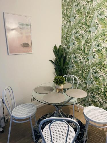 a group of tables and chairs in a room at 2 bedroom Beach cafes shops bus all a walk away in Deewhy