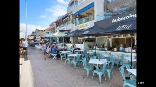 a group of people sitting at tables outside a restaurant at 2 bedroom Beach cafes shops bus all a walk away in Deewhy