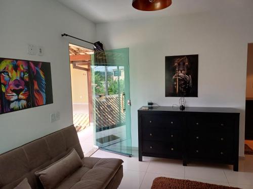 a living room with a couch and a dresser at Pousada Tia Rosi com suites independente 100 mts da praia c ar, energia solar e atendimento vip in Rio das Ostras