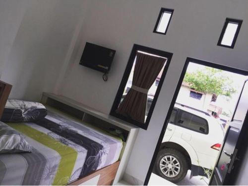 Sungai LutusにあるJameela Kostのベッドルーム1室(ベッド1台、鏡、白いトラック付)