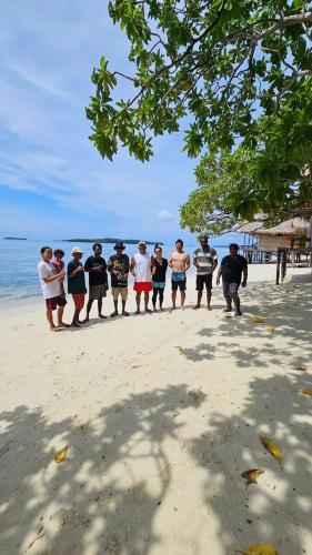 a group of people standing on the beach at Yefkabu Homestay Raja Ampat in Waisai