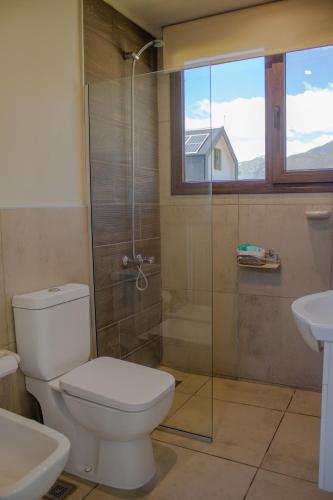 a bathroom with a toilet and a glass shower at El Rincón in Trevelín
