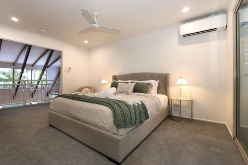 a bedroom with a bed and a ceiling fan at 6 Dooley Street Bargara in Bargara