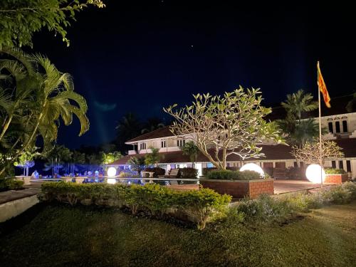 a night view of a house with lights at Green Island Hotel Waikkal in Waikkal