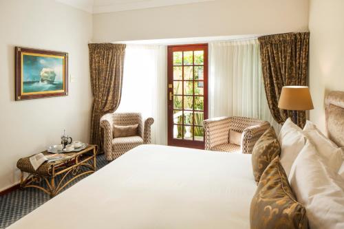 Habitación de hotel con cama y ventana en Kingfisher GuestHouse, en Port Elizabeth