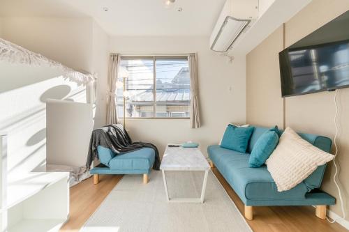 a living room with a blue couch and a tv at Urban Villa Sumida in Tokyo