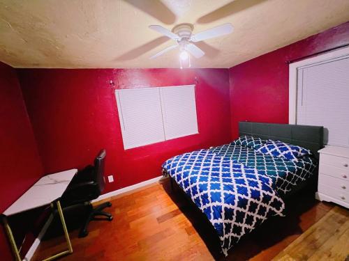 a bedroom with red walls and a bed and a desk at Pet friendly 2 bedroom located in the heart of OKC in Oklahoma City