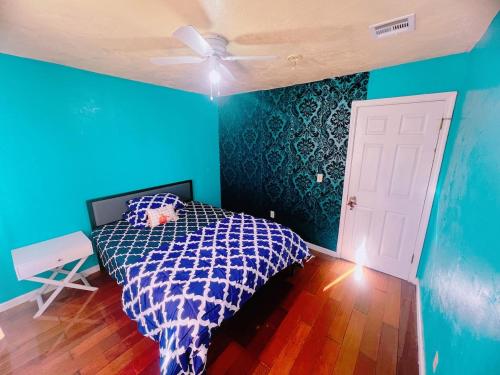 a blue bedroom with a bed and a ceiling fan at Pet friendly 2 bedroom located in the heart of OKC in Oklahoma City