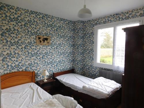 une chambre avec deux lits et une fenêtre dans l'établissement Gîte MMR 6 places avec cour clôturée, à Saint-Saturnin