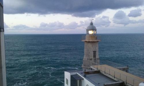 a lighthouse sitting on top of the ocean at Lekeitio Aterpetxea Hostel in Lekeitio