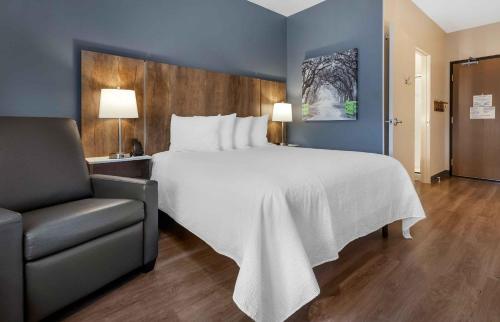 a bedroom with a large white bed and a chair at Extended Stay America Premier Suites - Charlottesville in Charlottesville