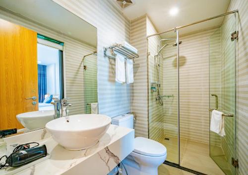 a bathroom with a sink and a toilet and a shower at Kim Sentral Hotel in Ha Long