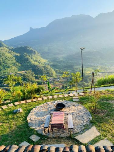 a table and two chairs sitting on a stone circle at Du peak home in Làng Cac