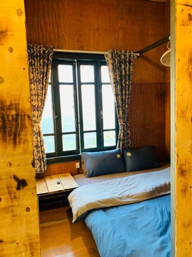 a bed in a room with a large window at Du peak home in Làng Cac