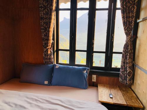 a bed in a room with a large window at Du peak home in Làng Cac