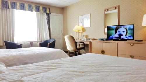 a hotel room with two beds and a flat screen tv at Hotel Motel Penn-Mass in Trois-Rivières