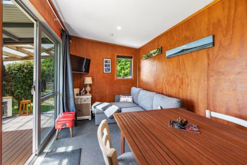 a living room with a table and a couch at Onaeros Cute Little Cottages - Taranaki Retreat in Waitara