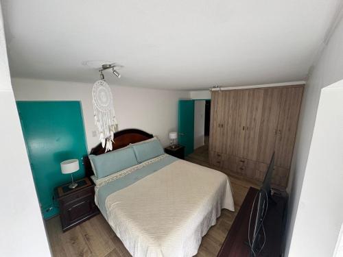 a bedroom with a bed and a flat screen tv at Vista al mar turquesa de Bahia in Calderilla