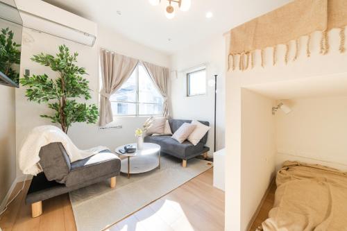a living room with two chairs and a couch at Urban Villa Sumida in Tokyo