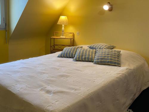 une chambre avec un grand lit blanc avec deux oreillers dans l'établissement Maison charmante près du château de Suscinio avec jardin et parking - FR-1-639-128, à Sarzeau