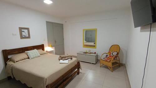 a bedroom with a bed and a chair and a mirror at Apartamento con Jardín Privado en Tarija - Precio al Cambio Oficial in Tarija