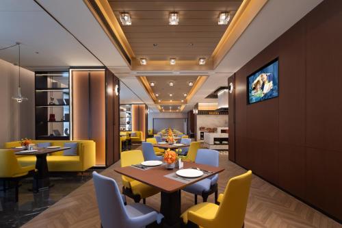 長沙市にあるHampton by Hilton Changsha Wuyi Squareのダイニングルーム(テーブル、黄色い椅子付)