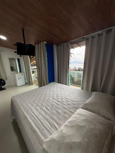 a bedroom with a large bed and a large window at Casa Panorâmica in Angra dos Reis
