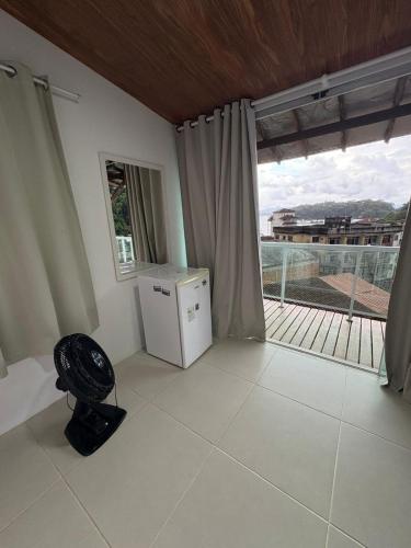 a living room with a refrigerator and a balcony at Casa Panorâmica in Angra dos Reis