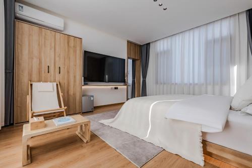 a bedroom with a large bed and a tv at 墨弦苑智能轻奢民宿 喜洲镇海舌公园店 in Dali