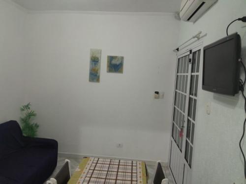 a living room with a tv and a couch at Aconchego in Praia Grande