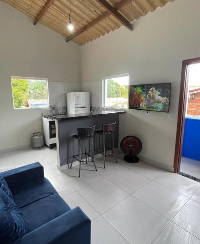 a living room with a blue couch and a kitchen at Casa good vibes in Pipa