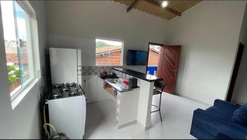 a white kitchen with a stove and a counter top at Casa good vibes in Pipa