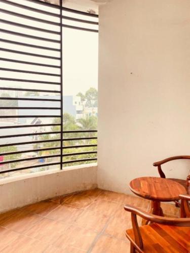 a room with a table and a large window at Candy Hotel Can Tho in Cái Răng