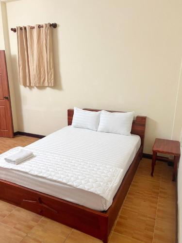 a bed with white sheets and pillows in a room at Candy Hotel Can Tho in Cái Răng