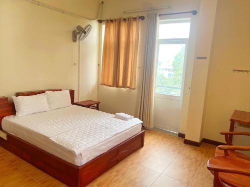 a bedroom with a bed and a large window at Candy Hotel Can Tho in Cái Răng