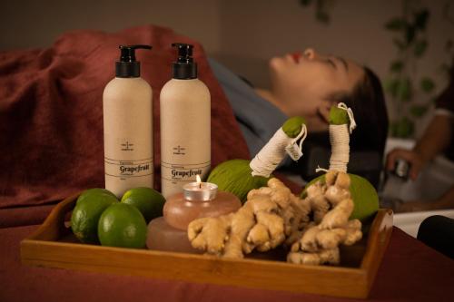 a tray with three bottles and limes and a candle at Hanoi Brilliant Hotel & Spa in Hanoi
