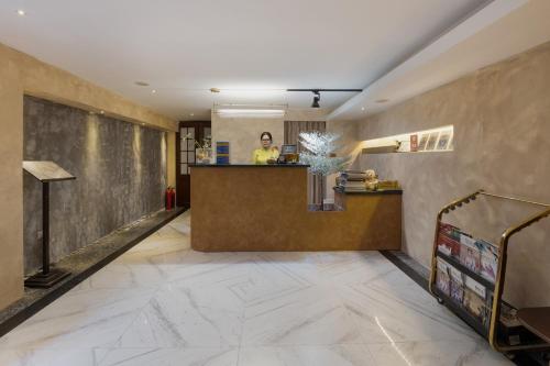 a lobby of a hotel with a woman standing at a counter at Hanoi Brilliant Hotel & Spa in Hanoi