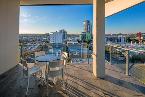 a balcony with a table and chairs and a view of the city at Direct Hotels - Pavilion and Governor on Brookes in Brisbane