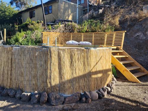 a hot tub with a wooden fence and a ladder at Luminosa casa valle de Elqui sector El Molle in Vicuña