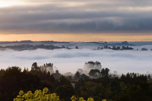 a view of a foggy valley with trees and clouds at Casa Observatorio de Chiloé in Castro