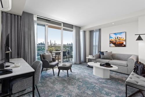 a living room filled with furniture and a large window at Punthill South Yarra Grand in Melbourne