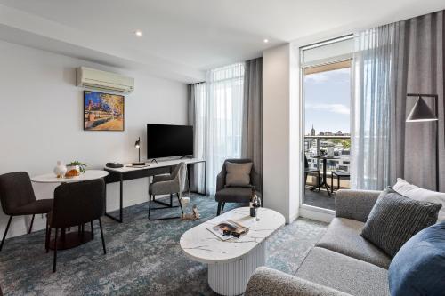 a living room with a couch and a table at Punthill South Yarra Grand in Melbourne