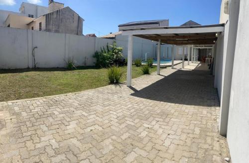 a patio with a pavilion next to a building at Recanto do Sol Praia do Cassino in Rio Grande