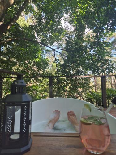 a table with a candle and a glass of wine at Romantic Getaway - 2 luxe outdoor baths in Mount Macedon