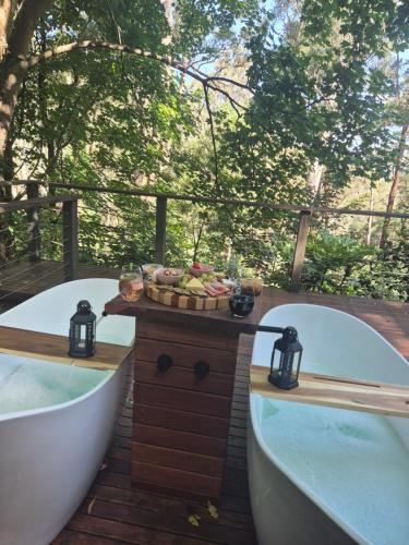 two bath tubs sitting on a deck with trees at Romantic Getaway - 2 luxe outdoor baths in Mount Macedon