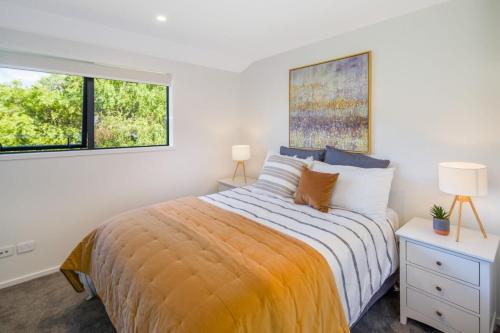 a bedroom with a bed and two windows at It's Gettin' HUT in Here in Lower Hutt