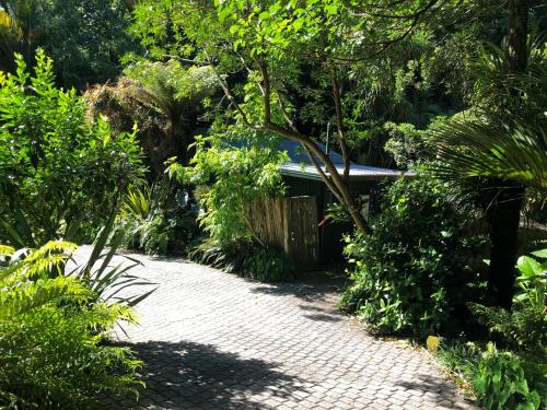 a garden with a brick walkway leading to a building at Tranquil Studio in New Plymouth
