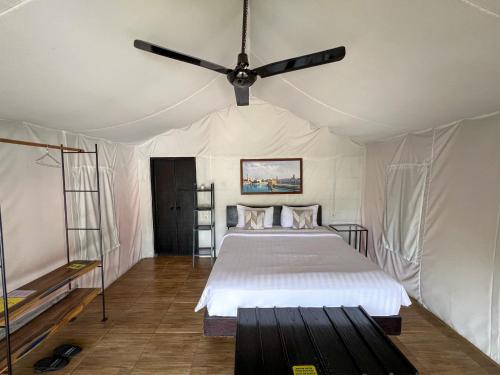 a bedroom with a bed and a ceiling fan at Trizara Resorts - Glam Camping in Lembang