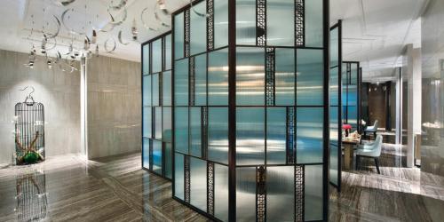 a glass wall in a room with a table at Crowne Plaza Baoji City Center by IHG in Baoji