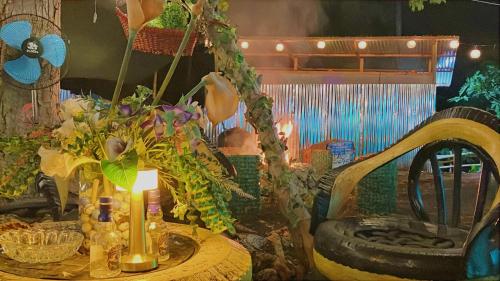 una mesa con una vela y un jarrón con flores en CampSarap Hostel & Resort, en Valencia